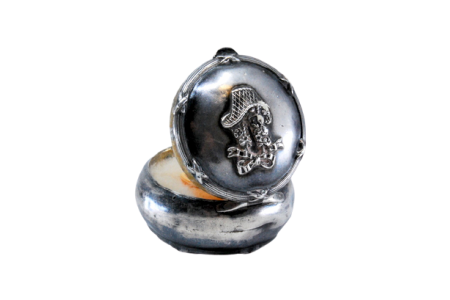 Caixa de toilette em prata de forma circular com espelho no interior e relevo na tampa.